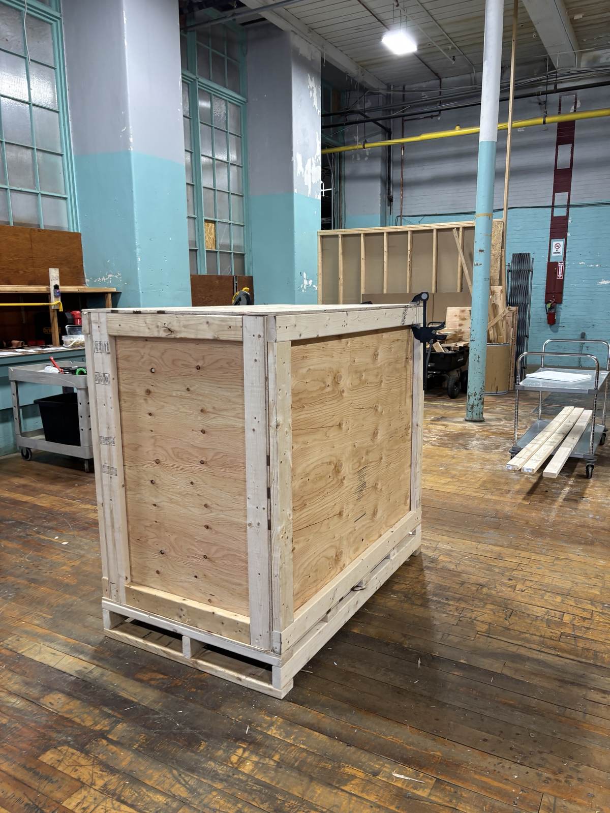 A finished custom crate against a warehouse wall.
