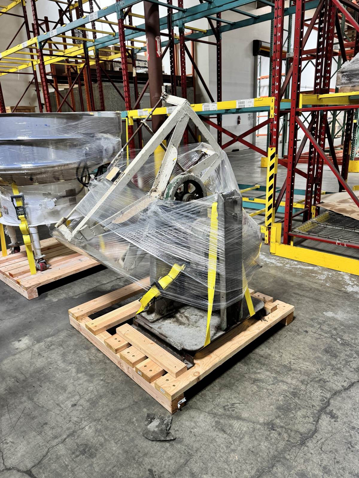 A vintage industrial machine, wrapped and staged for pickup.