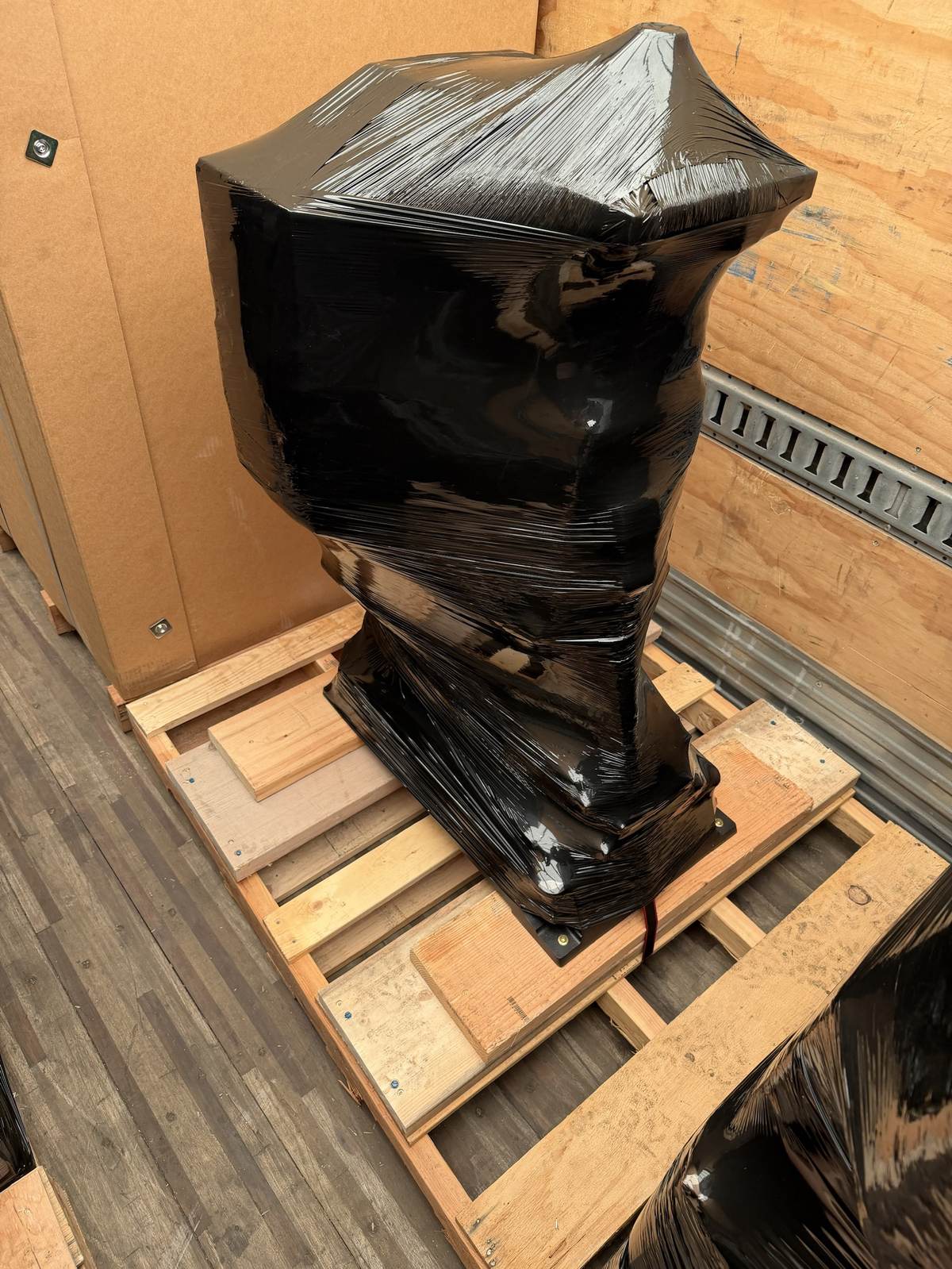 An oddly shaped piece of equipment, fully shrink-wrapped and strapped for freight.